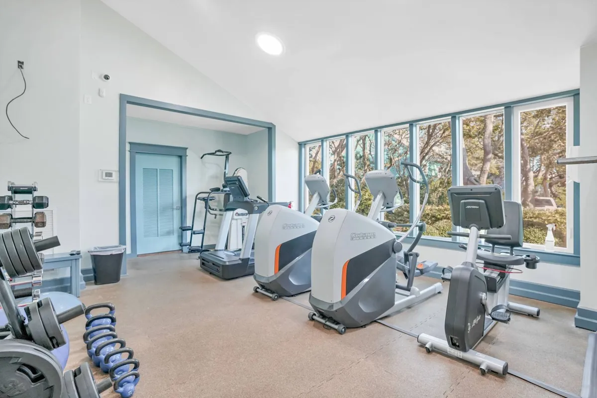 A bright, motivational fitness room filled with modern exercise equipment and large windows that invite natural light. The open layout encourages both solo workouts and group classes, supporting a healthy, active lifestyle for residents and guests.